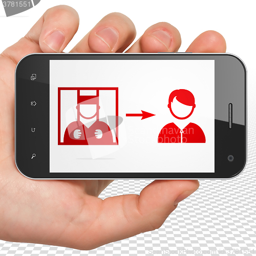 Image of Law concept: Hand Holding Smartphone with Criminal Freed on display
