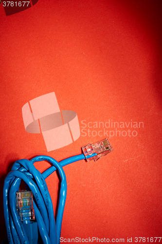 Image of Blue network cable on red background