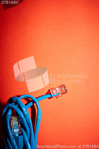 Image of Blue network cable on red background