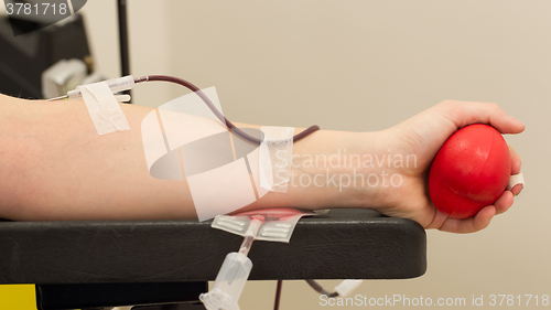 Image of Donor in an armchair donates blood,, close-up