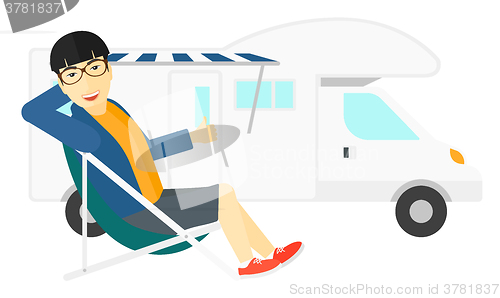 Image of Man sitting in front of motorhome.