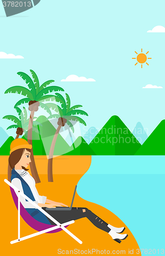 Image of Business woman sitting in chaise lounge with laptop.