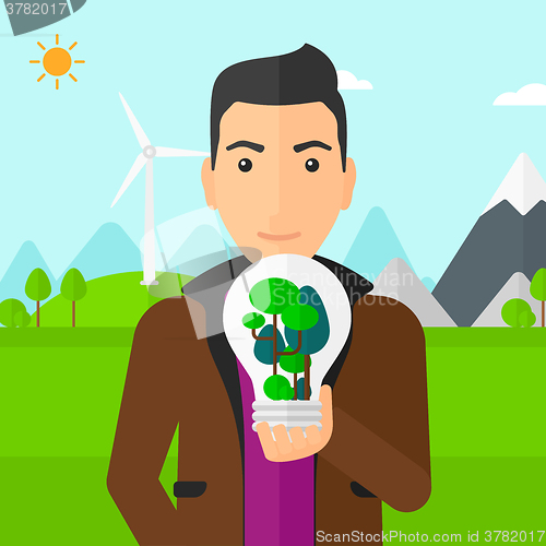 Image of Man with lightbulb and trees inside.