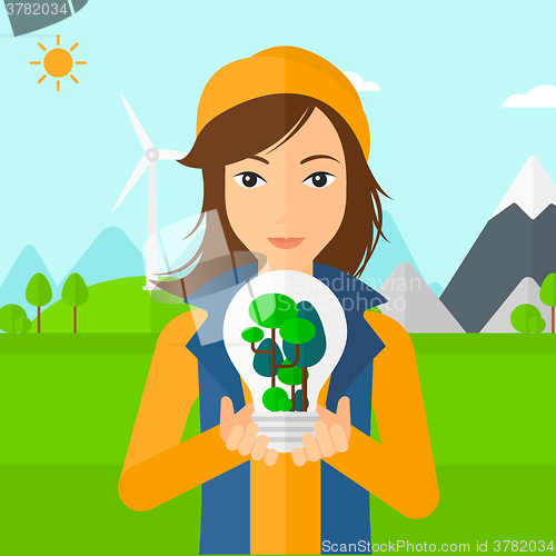 Image of Woman with lightbulb and trees inside.