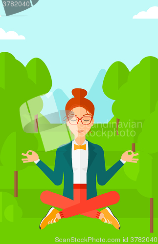 Image of Business woman meditating in lotus pose.