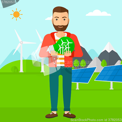 Image of Man holding lightbulb with windmills inside.