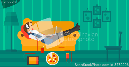 Image of Woman lying on sofa with many gadgets.