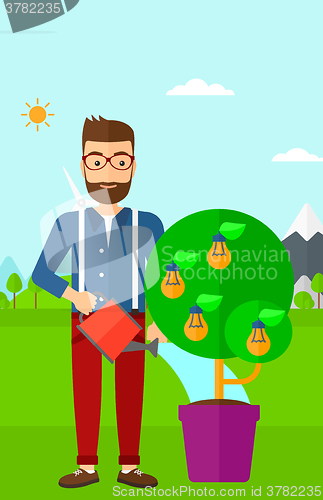 Image of Man watering tree with light bulbs.