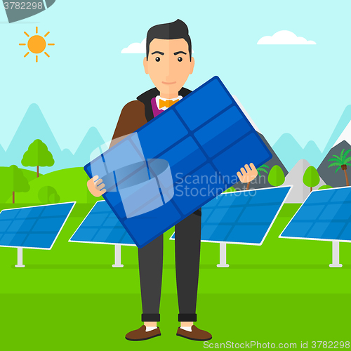 Image of Man holding solar panel.