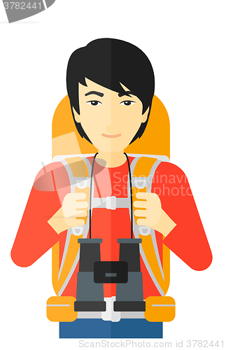 Image of Cheerful backpacker with binoculars.