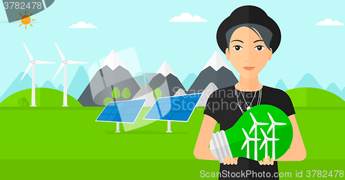 Image of Woman holding lightbulb with windmills inside.