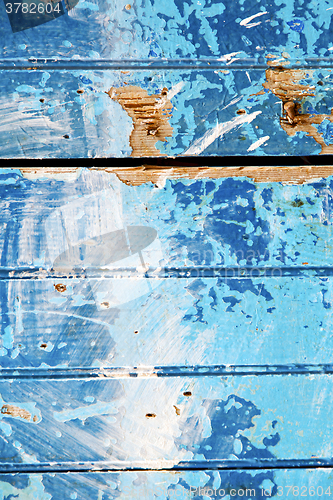 Image of stripped  in  blue   door and rusty nail