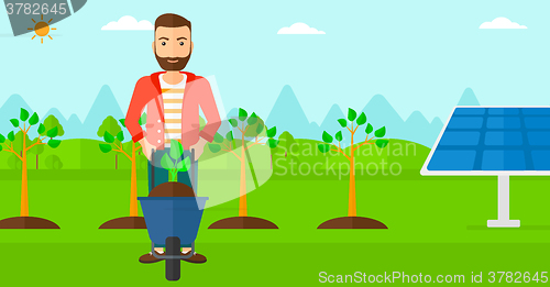 Image of Man with plant and wheelbarrow.