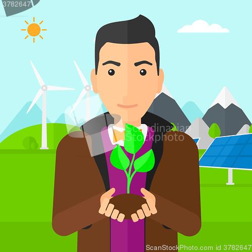 Image of Man holding plant.