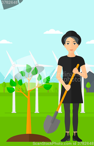 Image of Woman plants tree.