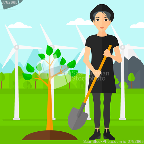 Image of Woman plants tree.