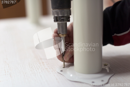 Image of repairman working with drilling machine