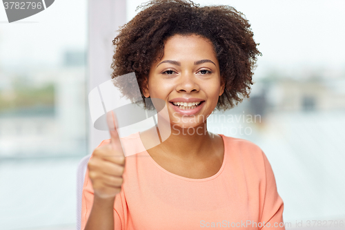 Image of happy african young woman showing thumbs up