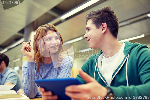 Image of happy students with tablet pc in library