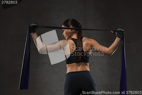 Image of woman with expander exercising in gym