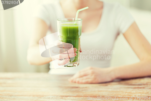 Image of close up of woman hands with green juice