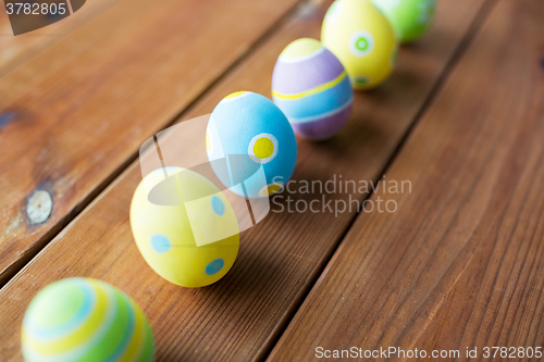 Image of close up of colored easter eggs on wooden surface