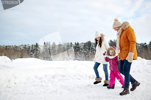 Image of happy family in winter clothes walking outdoors