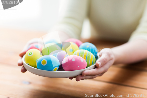 Image of close up of woman hands with colored easter eggs