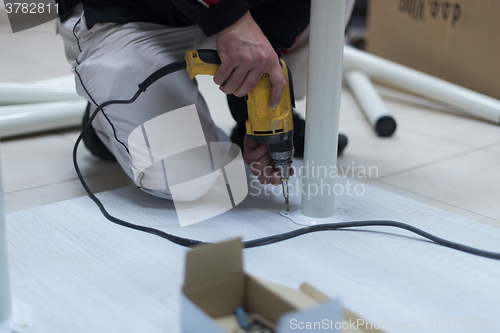 Image of repairman working with drilling machine