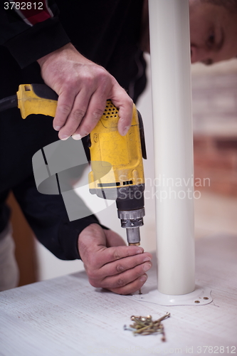 Image of repairman working with drilling machine