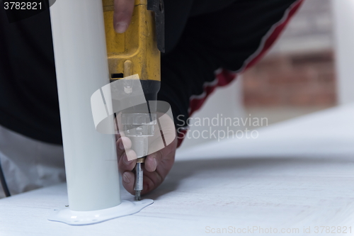 Image of repairman working with drilling machine