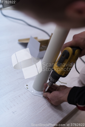 Image of repairman working with drilling machine