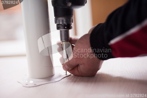 Image of repairman working with drilling machine