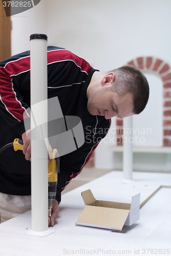 Image of repairman working with drilling machine