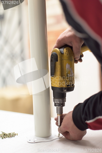 Image of repairman working with drilling machine