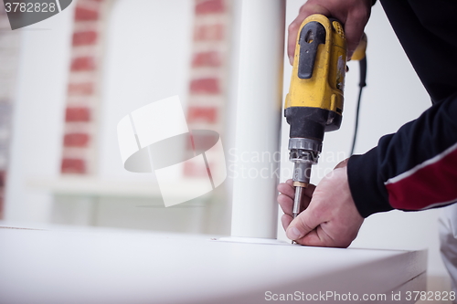 Image of repairman working with drilling machine