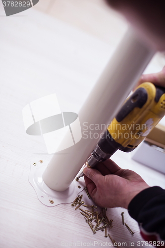 Image of repairman working with drilling machine