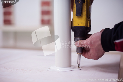 Image of repairman working with drilling machine