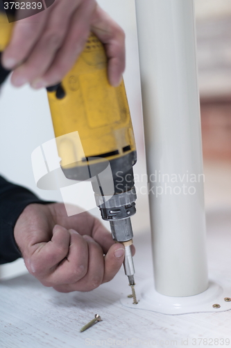 Image of repairman working with drilling machine