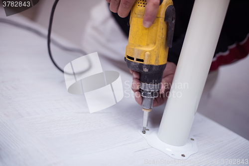 Image of repairman working with drilling machine