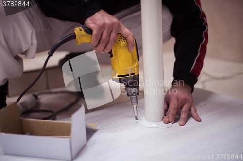 Image of repairman working with drilling machine