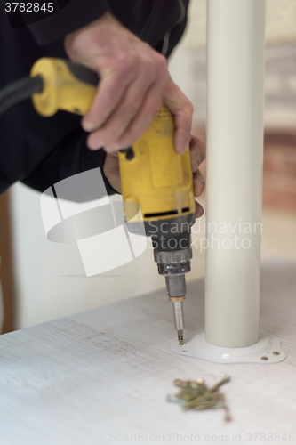 Image of repairman working with drilling machine