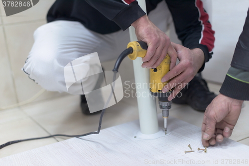 Image of repairman working with drilling machine