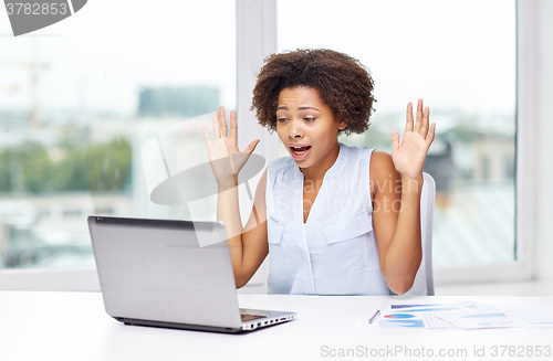 Image of african woman with laptop at office