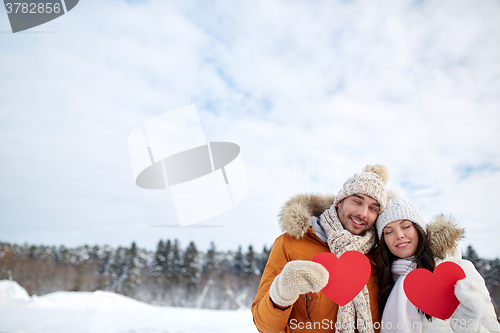 Image of happy couple with red hearts over winter landscape