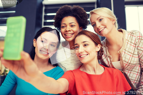 Image of happy young women taking selfie with smartphone