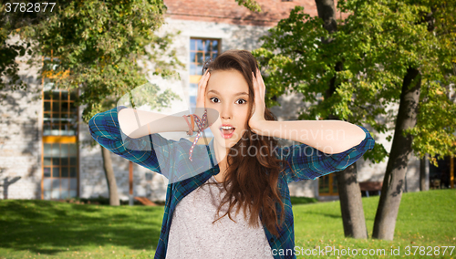 Image of pretty teenage student girl holding to head