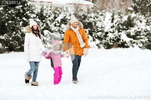 Image of happy family in winter clothes walking outdoors