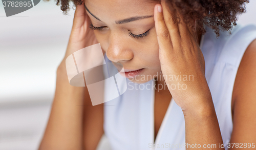 Image of close up of african young woman touching her head