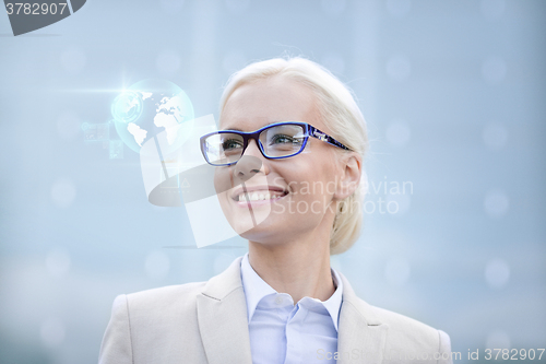 Image of young smiling businesswoman in eyeglasses outdoors